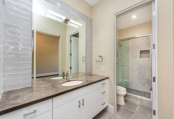 Modern shower remodel in South Pasadena featuring herringbone-patterned wall tiles and a hexagonal mosaic floor.