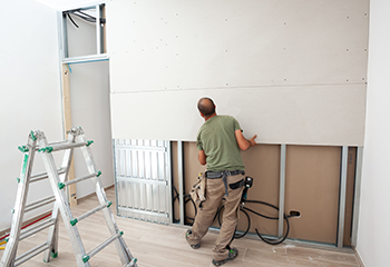 Drywall installation process during living room remodeling in Alhambra.