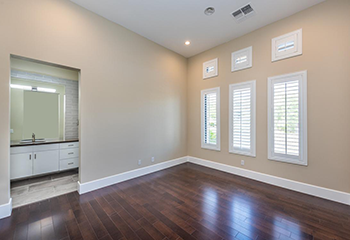 Remodeled living room in Pasadena featuring natural-look hardwood floors, recessed lighting, and custom window shutters.